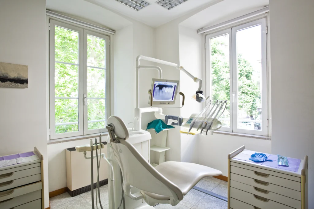 A treatment chair in a dentist's office overlooking a window